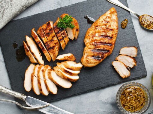 Blanc de poulet grillé et tranché – Un filet de poulet grillé à la perfection, marqué de belles striures dorées, servi sur une ardoise élégante. Découpé en fines tranches, il est accompagné de graines de moutarde, de persil frais et d’un filet d’huile d’olive pour sublimer sa saveur. Une présentation raffinée idéale pour une cuisine saine et gourmande.